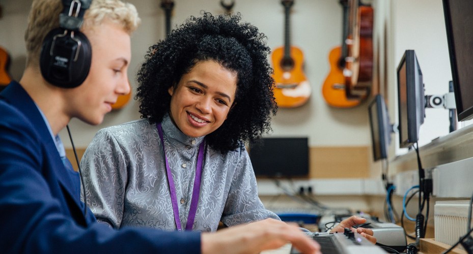student and art teacher listening to recording track