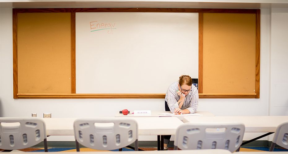 teacher in empty classroom thinking about the teacher job market