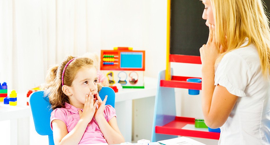speech therapist works with young girl on her enunciation skills