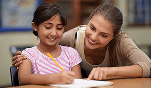 teacher pointing out fact with child on her homework