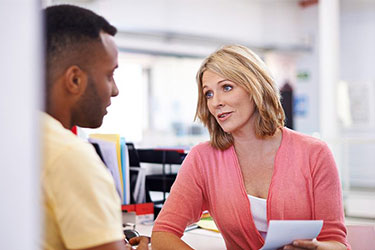school office clerk talking to male teacher