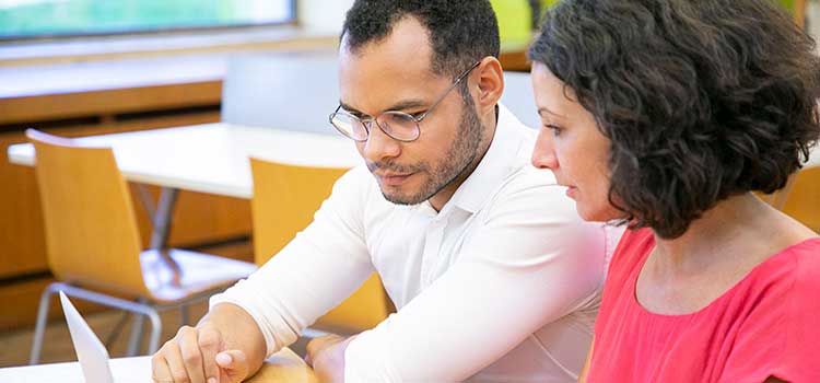 man and woman research on laptop