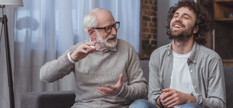 grandfather and grandson laughing together on couch