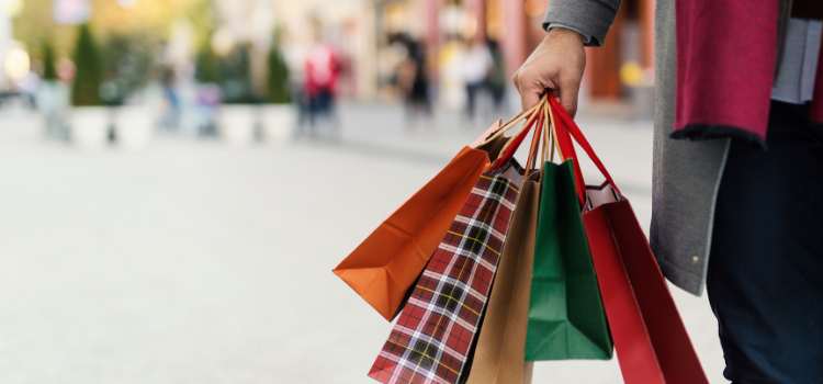 man holding five shopping bags