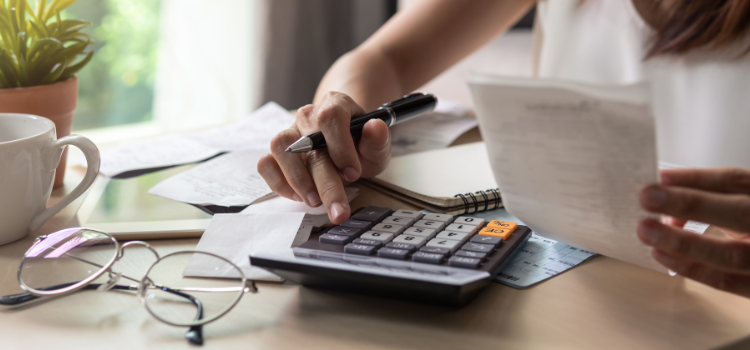 woman calculating expenses on calculator and looking at receipt