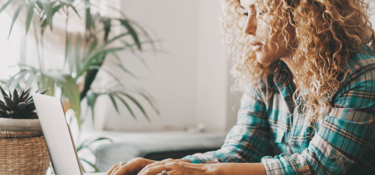 woman sitting and typing on laptop