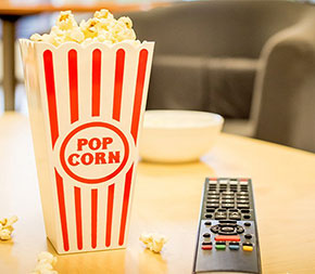 popcorn and remote control to get ready to watch movies about teachers