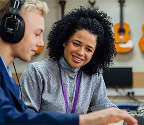 student and art teacher listening to recording track