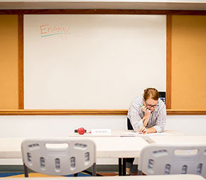 teacher in empty classroom thinking about the teacher job market