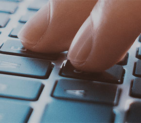 closeup of hands typing on computer keyboard