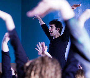 teacher leads a drama class in movement exercises
