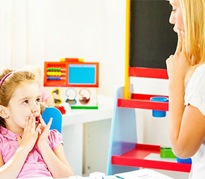 speech therapist works with young girl on her enunciation skills