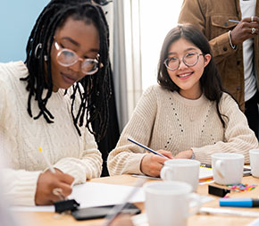 two college students filling out forms at coffeehouse