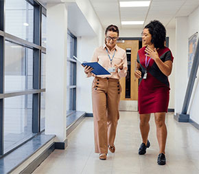 two teachers walking together in hallway