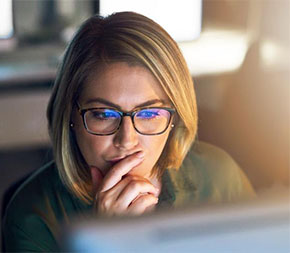 woman doing research on teaching degrees on computer